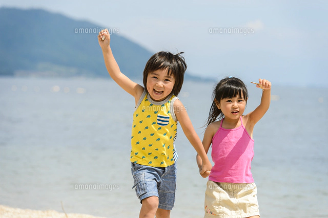 海辺の砂浜でうつ伏せになる水着の子供[10264007041]の写真・イラスト