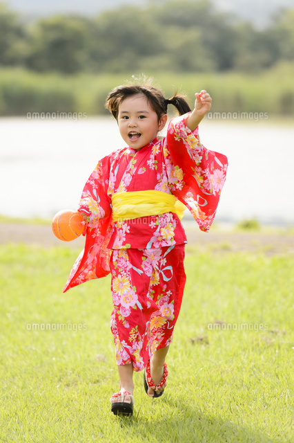 芝生を走る浴衣の女の子 の写真素材 イラスト素材 アマナイメージズ