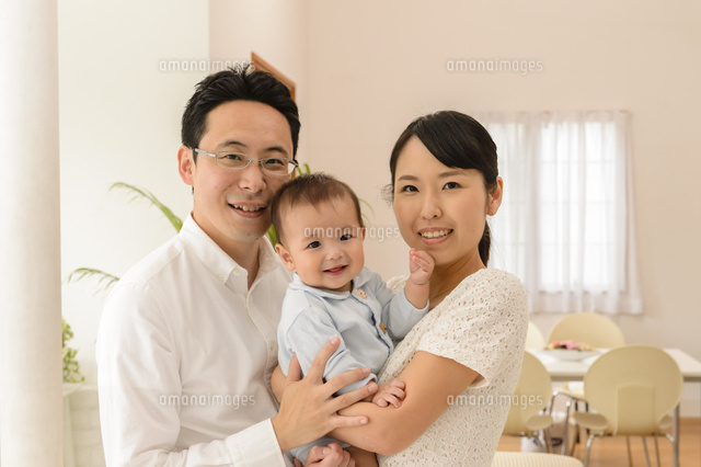 赤ちゃんを抱っこするお母さんとお父さん[10264006919]の写真