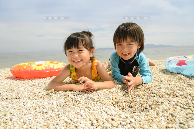 海辺の子供 海辺の砂浜で遊ぶ水着の子供[10264006698]の写真・イラスト素材