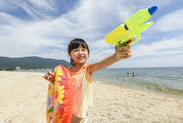 浮き輪と水鉄砲を持って遊ぶ女の子 の写真素材 イラスト素材 アマナイメージズ