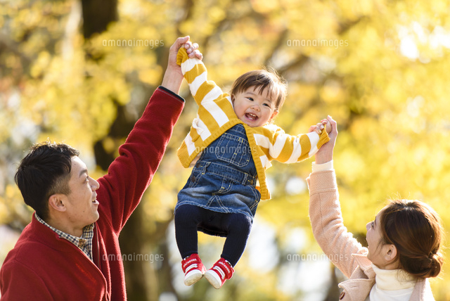 紅葉の公園で高い高いする親子 の写真素材 イラスト素材 アマナイメージズ