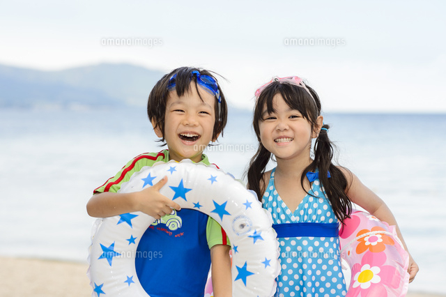 夏の海で浮き輪を持って並ぶ女の子と男の子 の写真素材 イラスト素材 アマナイメージズ