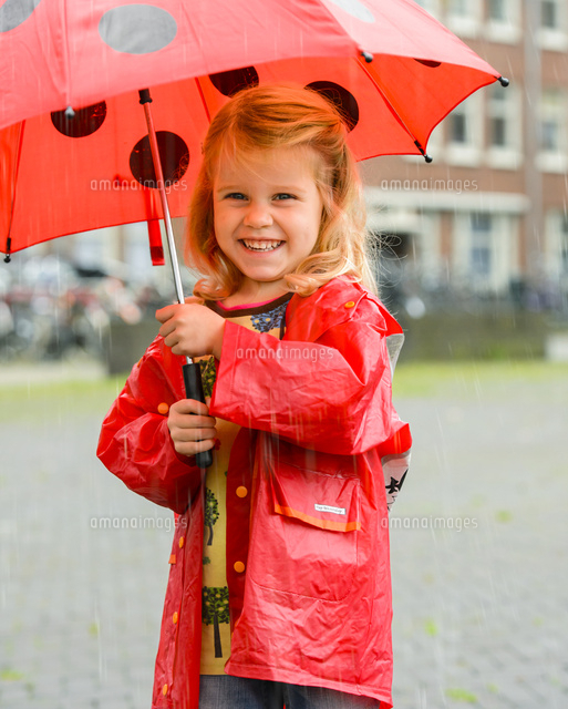 レインコートを着て傘をさす女の子 の写真素材 イラスト素材 アマナイメージズ