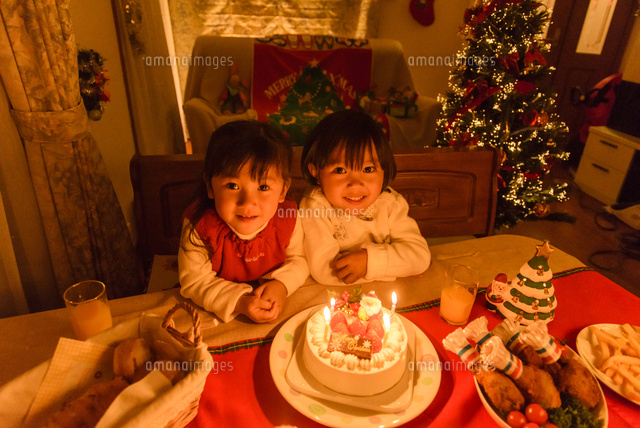 クリスマスパーテイーにご馳走が並ぶテーブルの前に座る女の子 の写真素材 イラスト素材 アマナイメージズ