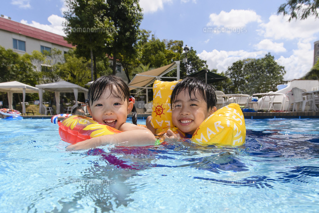 プールで浮き輪で遊ぶ男の子と女の子 の写真素材 イラスト素材 アマナイメージズ