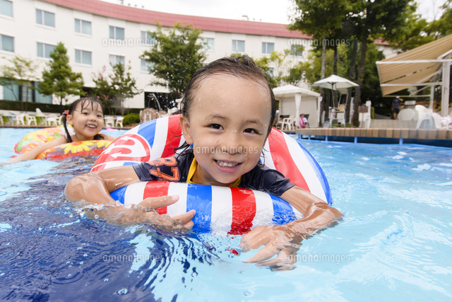 プールで浮き輪で遊ぶ男の子と女の子 の写真素材 イラスト素材 アマナイメージズ