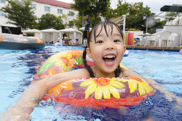 プールで浮き輪で遊ぶ女の子 の写真素材 イラスト素材 アマナイメージズ