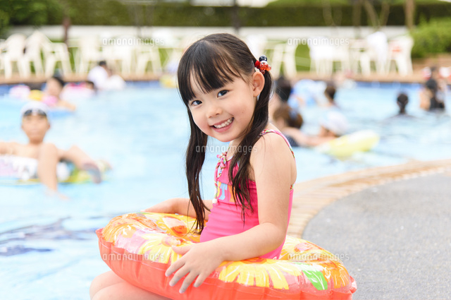 プールに腰掛ける浮き輪を持った女の子 の写真素材 イラスト素材 アマナイメージズ
