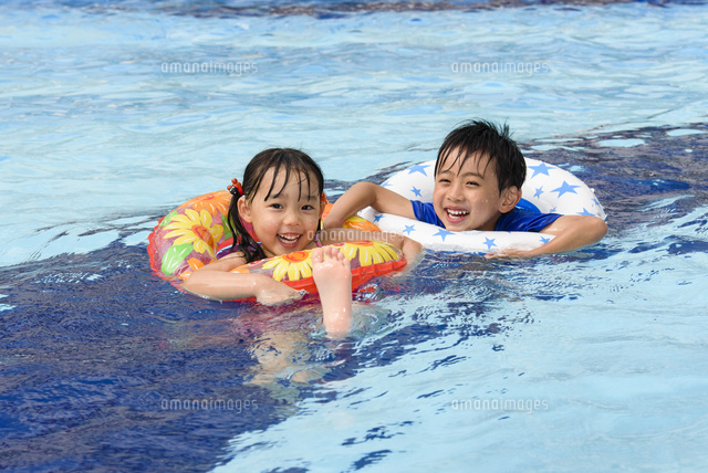 プールで浮き輪で遊ぶ女の子と男の子 の写真素材 イラスト素材 アマナイメージズ