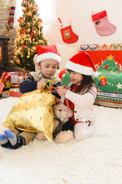 クリスマスプレゼントを開ける子供 の写真素材 イラスト素材 アマナイメージズ