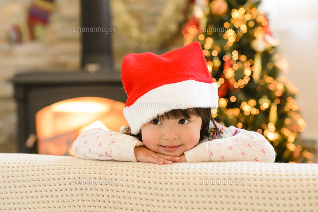 クリスマスツリーとサンタの帽子をかぶった子供 の写真素材 イラスト素材 アマナイメージズ