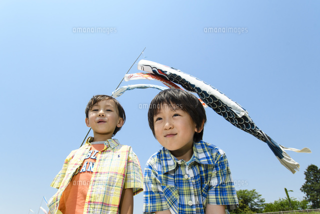 鯉のぼり泳ぐ青空の下で並んでる男の子 の写真素材 イラスト素材 アマナイメージズ