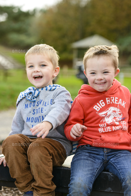 公園のベンチに仲良く座る男の子 の写真素材 イラスト素材 アマナイメージズ