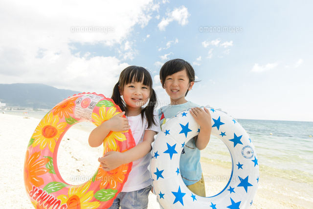 浮き輪を持って並んで立つ男の子と女の子 の写真素材 イラスト素材 アマナイメージズ