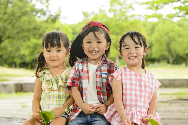 並んで公園のベンチに座った男の子と女の子 の写真素材 イラスト素材 アマナイメージズ