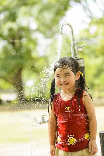 公園の水飲み場で水遊びする女の子 の写真素材 イラスト素材 アマナイメージズ