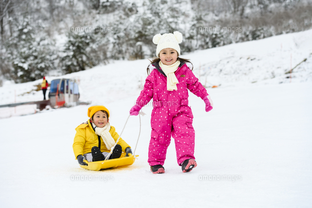 雪山でソリで遊ぶ子供 の写真素材 イラスト素材 アマナイメージズ