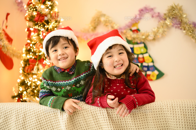 クリスマスツリーとサンタ帽をかぶった男の子と女の子 の写真素材 イラスト素材 アマナイメージズ