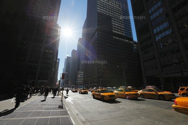 摩天楼上空を移動する太陽と影と車列 の写真素材 イラスト素材 アマナイメージズ