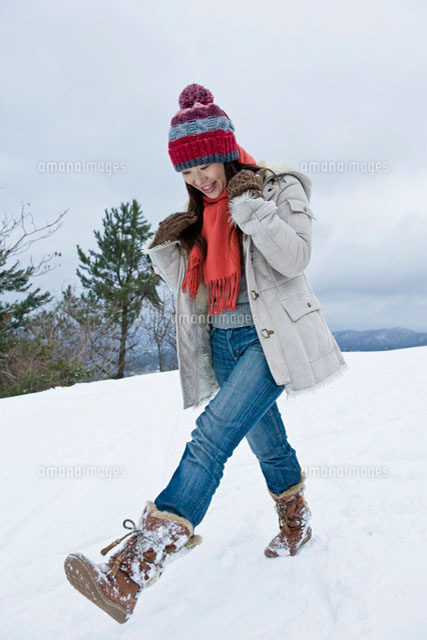 雪の中を歩く日本人女性 の写真素材 イラスト素材 アマナイメージズ