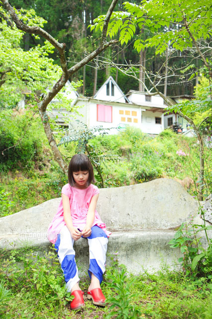 石のイスに座ってうつむくハーフの女の子 の写真素材 イラスト素材 アマナイメージズ