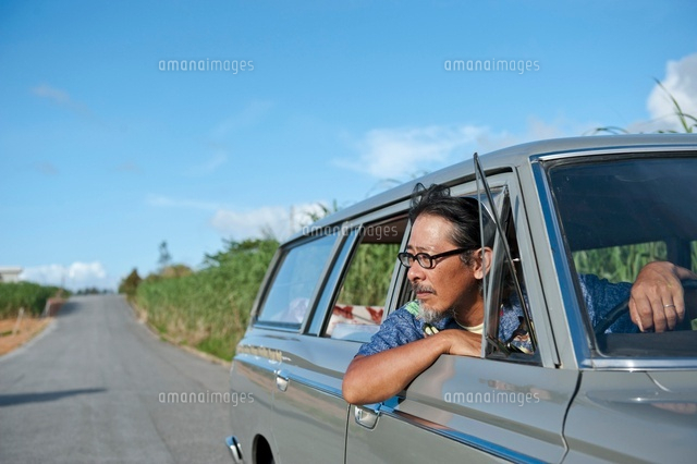 車の窓から顔をだす日本人男性 の写真素材 イラスト素材 アマナイメージズ