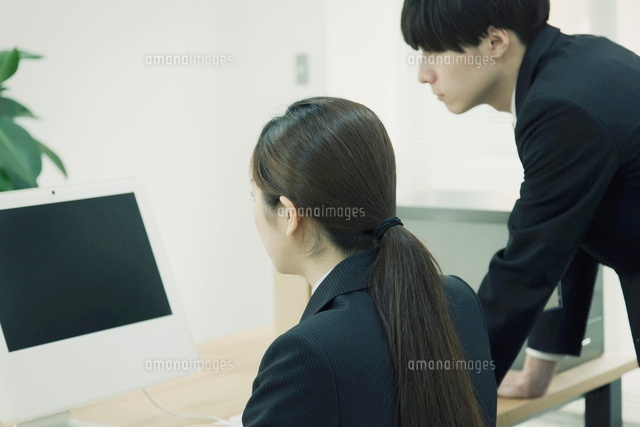 パソコンを見るスーツ姿の男女 の写真素材 イラスト素材 アマナイメージズ