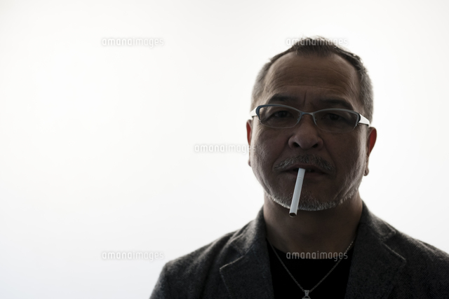 ねずみの被り物をしてタバコを吸う男性 タバコを吸う日本人男性[10272004178]の写真・イラスト素材｜アマナ