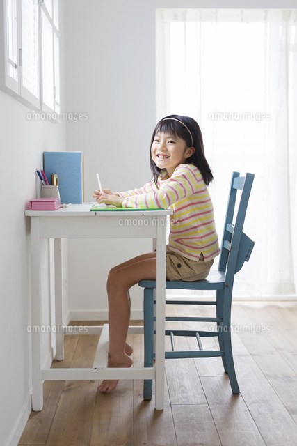 机に向かう小学生の女の子 の写真素材 イラスト素材 アマナイメージズ