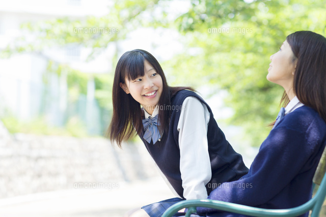 ベンチに座る2人の日本人の女子高生[10272004973]の写真・イラスト 