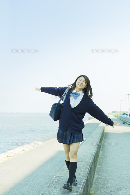 防波堤を歩く日本人女子高生 の写真素材 イラスト素材 アマナイメージズ