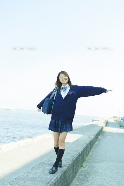 防波堤を歩く日本人女子高生 の写真素材 イラスト素材 アマナイメージズ