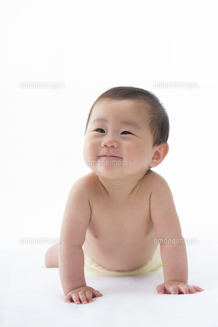 白いシーツの上で腹ばいになっている笑顔の赤ちゃん の写真素材 イラスト素材 アマナイメージズ