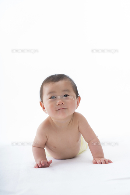白いシーツの上で腹ばいになって上を見る笑顔の赤ちゃん の写真素材 イラスト素材 アマナイメージズ