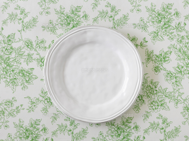緑のボタニカル柄の布と白の丸い皿[10331000305]の写真・イラスト素材  