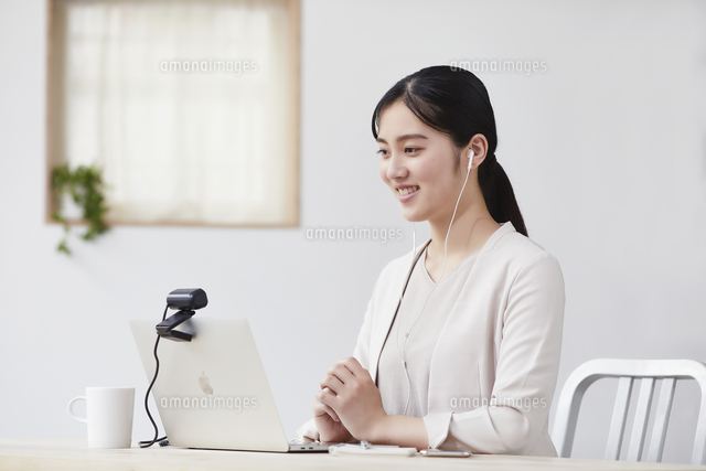 パソコンの前で仕事をする若い女性 の写真素材 イラスト素材 アマナイメージズ