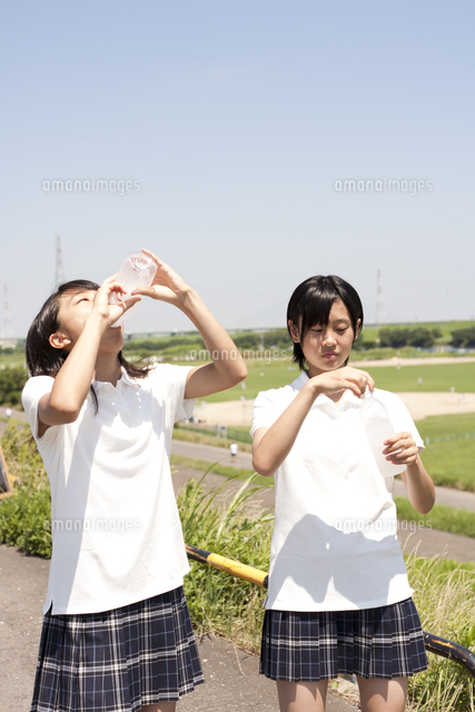 ペットボトルの水を飲む仲良し女子高生 の写真素材 イラスト素材 アマナイメージズ
