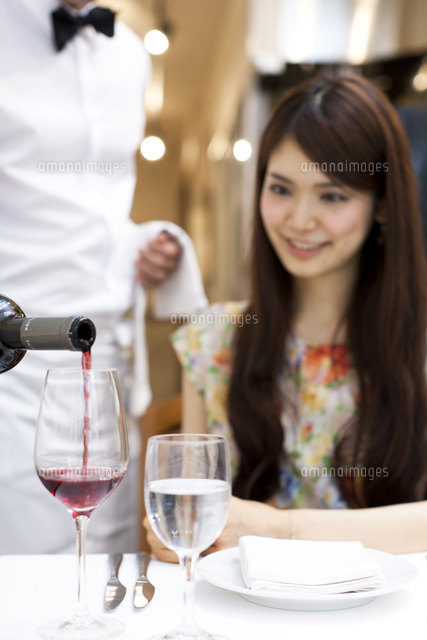 レストランでワインを注ぐウエイター ソムリエ と笑顔の女性客 の写真素材 イラスト素材 アマナイメージズ