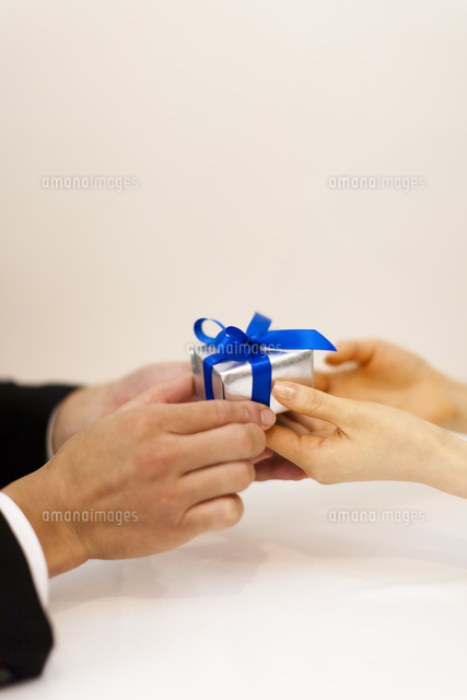 レストランで指輪を持ちプロポーズする男性と女性の添えた手 の写真素材 イラスト素材 アマナイメージズ