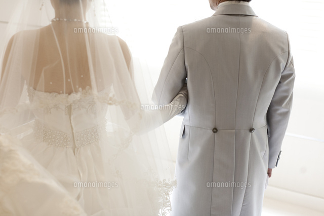 結婚式で腕を組み歩く新郎新婦の後ろ姿 の写真素材 イラスト素材 アマナイメージズ