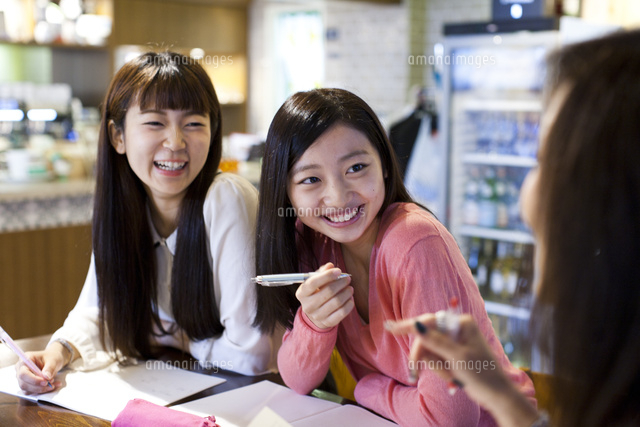 カフェで楽しそうにプライベートレッスンを受ける笑顔の女性ふたり の写真素材 イラスト素材 アマナイメージズ