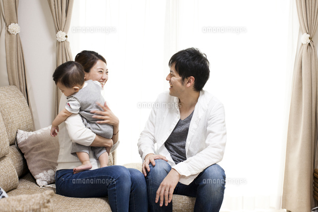 リビングで赤ちゃんをあやしながら遊ぶ楽しそうな笑顔の夫婦 の写真素材 イラスト素材 アマナイメージズ