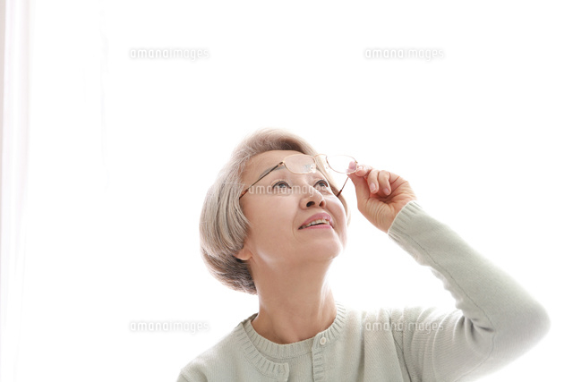 メガネを持っている老眼の老年女性 の写真素材 イラスト素材 アマナイメージズ