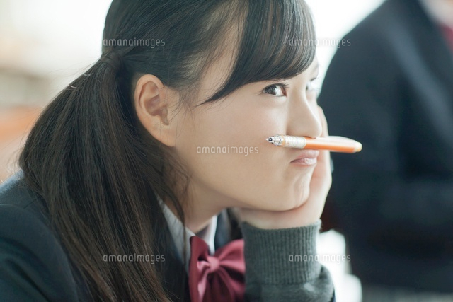 授業中鉛筆を口の上に乗せる女子校生 の写真素材 イラスト素材 アマナイメージズ