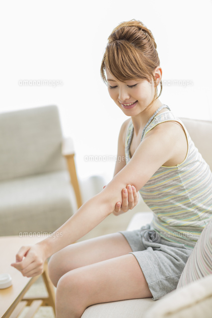 腕にクリームを塗る女性 の写真素材 イラスト素材 アマナイメージズ
