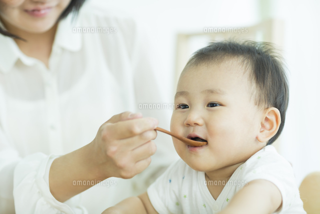 スプーンでご飯を食べさせてもらう赤ちゃん の写真素材 イラスト素材 アマナイメージズ