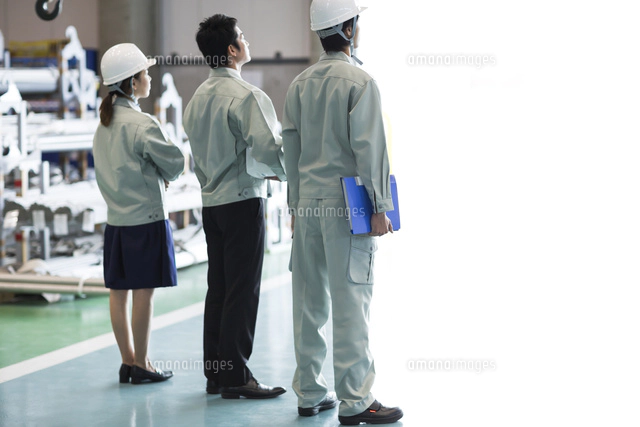 工場に立つ男女作業員の後姿 の写真素材 イラスト素材 アマナイメージズ