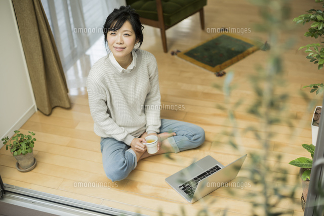 窓辺で外を見上げる若い女性 の写真素材 イラスト素材 アマナイメージズ