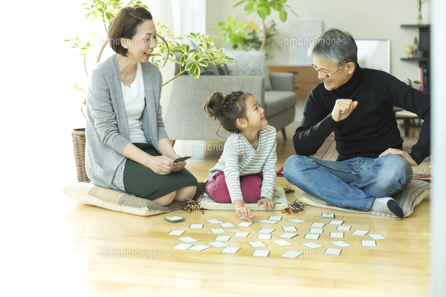 カルタで遊ぶ女の子とシニア夫婦 の写真素材 イラスト素材 アマナイメージズ